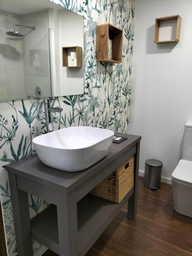 a bathroom with a large white sink on a table at Habitación en apartamento in Port Saplaya
