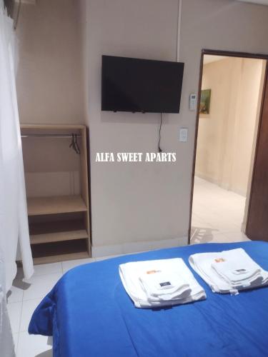 a room with a bed with a tv and two towels at ALFA SWEET APARTS in Formosa