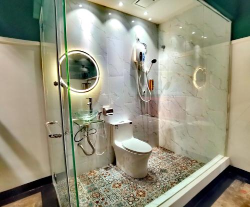 ein Bad mit einem WC und einer Glasdusche in der Unterkunft 1 Day Car Hotel - BG Perdana in Batu Gagah