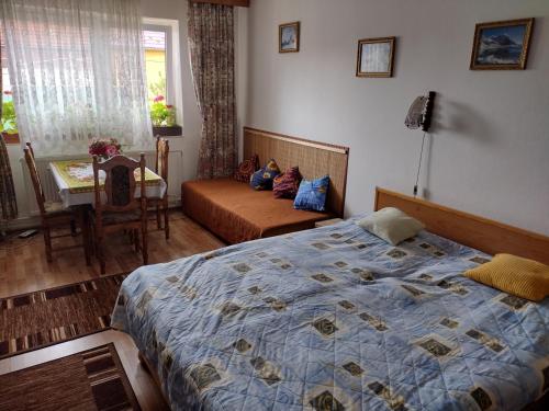 a bedroom with a bed and a table and a chair at Dom pod Tatrami. in Veľký Slavkov