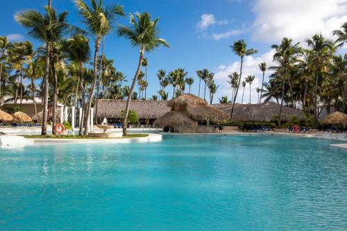 a swimming pool at a resort with palm trees at Grand Palladium Palace Resort Spa & Casino - All Inclusive in Punta Cana