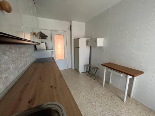 una piccola cucina con tavolo e frigorifero di Alojamiento Marmolejo a Marmolejo
