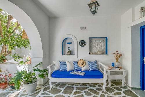 a white room with a blue couch on a patio at Alpha Studios in Naousa