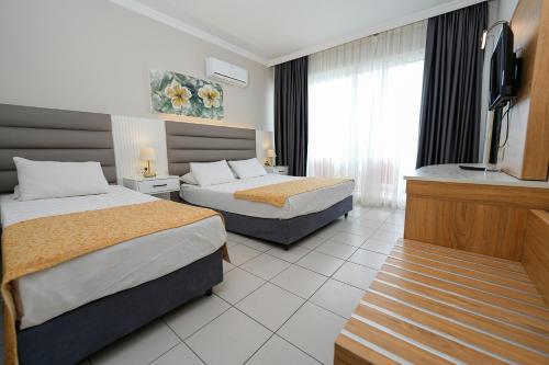 a hotel room with two beds and a flat screen tv at Side Beach Club in Side