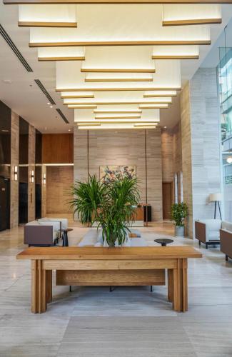 a large lobby with a table and a large chandelier at Signature by M Village Lê Thánh Tôn in Ho Chi Minh City