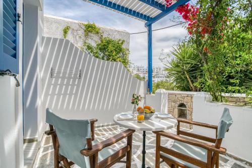 a patio with a table and chairs and a white fence at Alpha Studios in Naousa