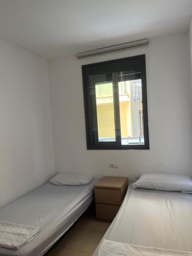 two twin beds in a room with a window at Apartamento in Lloret de Mar
