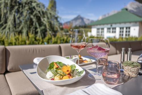 a table with a bowl of food and glasses of wine at Hotel Pirchnerhof in Reith im Alpbachtal