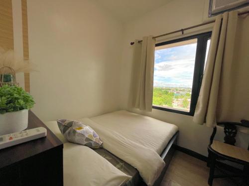 a small bedroom with a bed and a window at Althea's Cozy Apartment in Manila