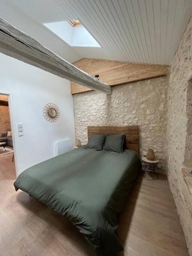 - une chambre avec un lit vert dans un mur en pierre dans l'établissement La Pierre Pourpre, à Eymet