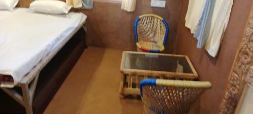 a room with two chairs and a bed and a table at Bendre's Farm Stay-Neral in Neral