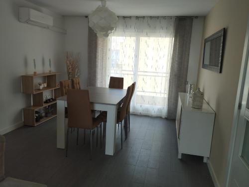 a kitchen and dining room with a white table and chairs at Ático Frente al Mar con Parking para 5 personas in Calafell