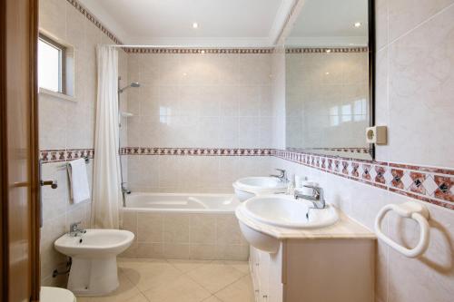 een badkamer met 2 wastafels en een bad bij Yara Beach Apartments T1 in Albufeira