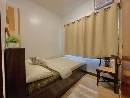 Cette petite chambre comprend un lit et une chaise. dans l'établissement Althea's Cozy Apartment, à Manille