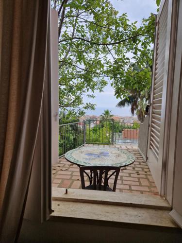 an open door with a table on a balcony at Hotel - Giardino Marchese D'Altavilla in Tropea