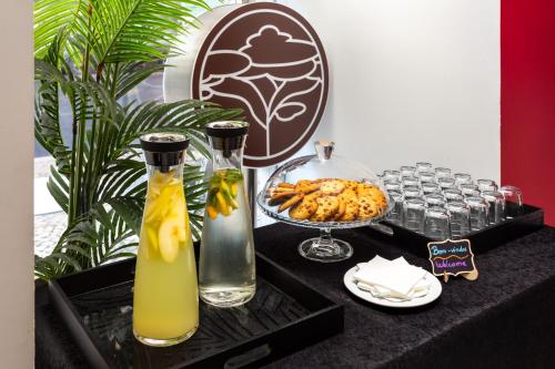 里斯本的住宿－盧埃納酒店，一张桌子,上面有两瓶花和一碗食物