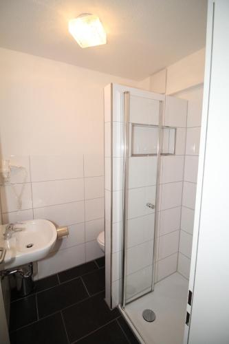 La salle de bains est pourvue d'une douche et d'un lavabo. dans l'établissement Gasthaus Bonneberger Hof, à Vlotho
