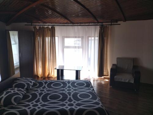 a bedroom with a bed and a chair and a window at Пансионат Сабрина in Bosteri