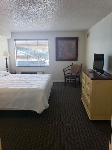 a hotel room with a bed and a desk with a television at Oak Ridge at Branson in Branson