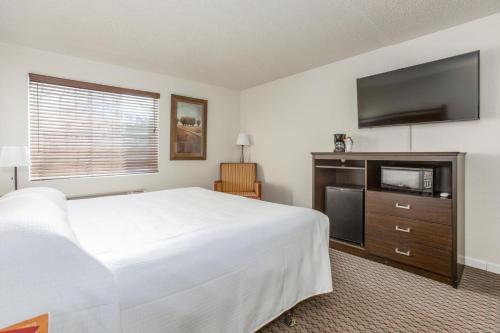 a hotel room with a bed and a flat screen tv at Oak Ridge at Branson in Branson