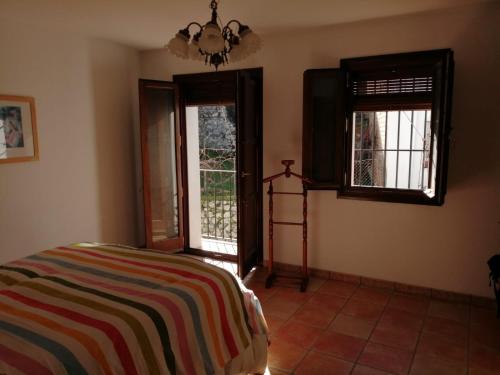 sypialnia z łóżkiem i 2 oknami w obiekcie La Casita Azul w mieście Grazalema