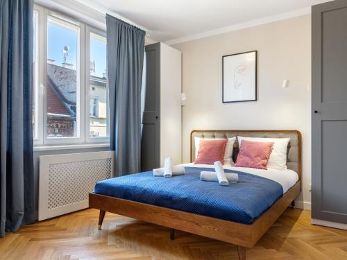 a bedroom with a bed and a window at Tyzenhauz Apartments Rakowicka Street in Krakow