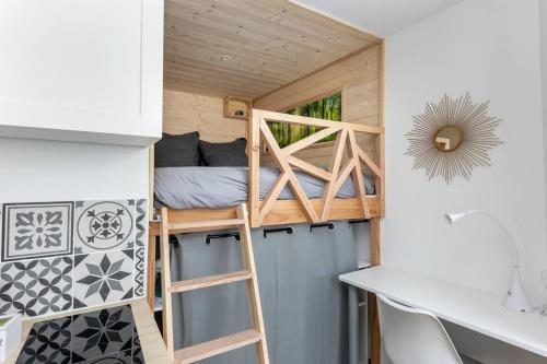 a tiny house with a bunk bed and a desk at La Cabane Urbaine in Brest