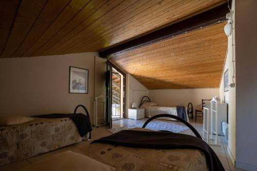een kamer met 2 bedden en een houten plafond bij VILLA BOTTERA with Jacuzzi in the garden Cuneo Langhe Piemonte in Riforano