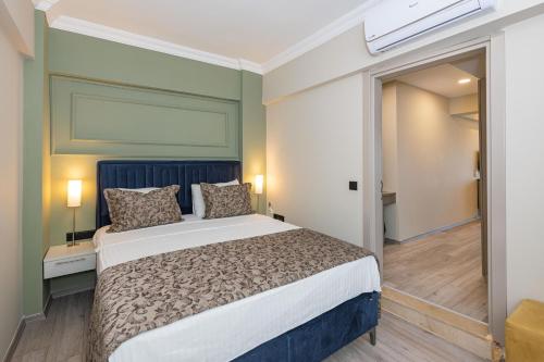 a bedroom with a large bed with a blue headboard at IDEE SUİTES Fethiye in Fethiye