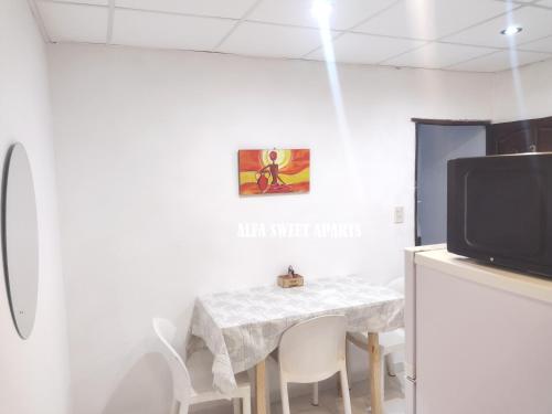 une salle à manger avec une table et une télévision dans l'établissement ALFA SWEET APARTS, à Formosa