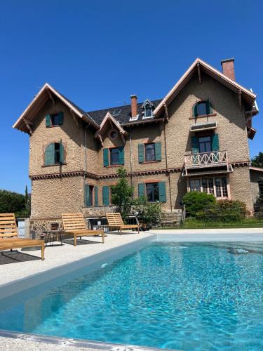 une grande maison avec une piscine devant dans l'établissement O'Cottage jardin, à Annonay