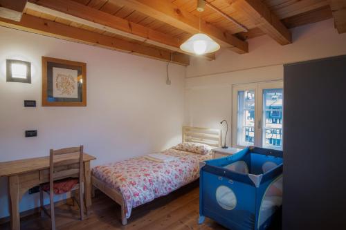 a bedroom with a bed and a desk and a table at La Casa del Noce in Fiera di Primiero
