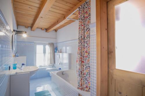 a bathroom with a tub and a sink at Casa del Noce in Fiera di Primiero