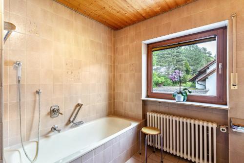 a bathroom with a bath tub and a window at Marlene in Friesenheim