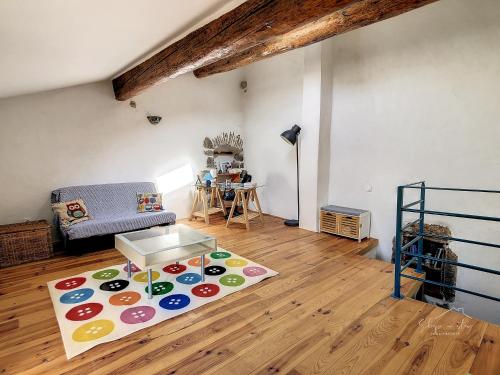 a living room with a couch and a rug at La maison aux volets bleus in Caunes-Minervois