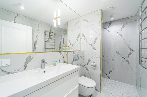 a white bathroom with a sink and a toilet at Modern Loft Apartment w/free parking No.2 in Marijampolė