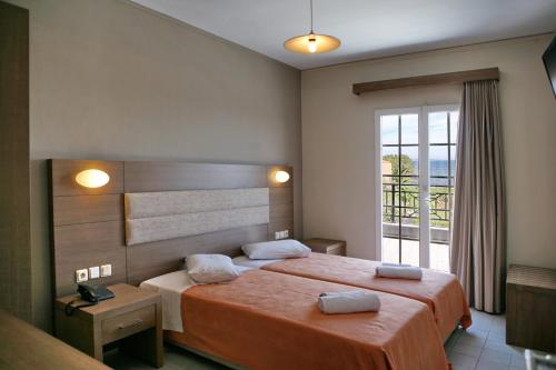 a bedroom with a large bed and a large window at Princess Studios Mitilini in Mytilene