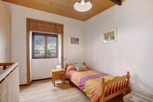een slaapkamer met een bed en een raam bij Casa La Zahorra in Teno Alto