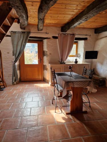 une pièce avec une table, des chaises et une porte dans l'établissement Gite rustique en Centre Bretagne, à Laniscat