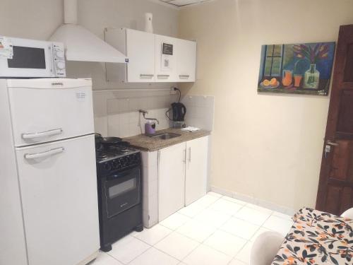 a kitchen with a white refrigerator and a stove at ALFA SWEET APARTS in Formosa