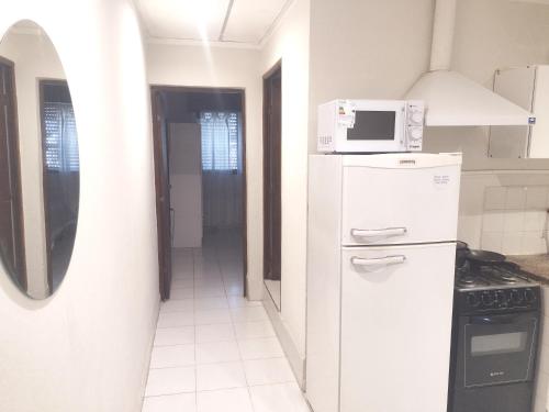a kitchen with a white refrigerator and a microwave at ALFA SWEET APARTS in Formosa