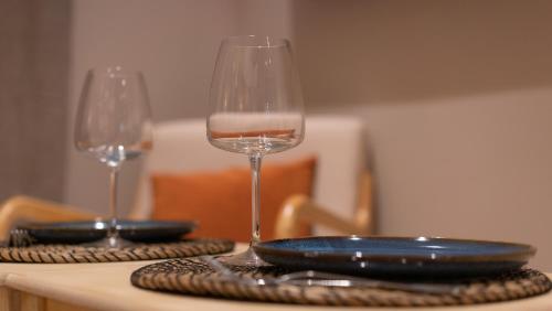 dos copas de vino sentadas sobre una mesa en Suite de Luxe Jacuzzi balnéo,King size Bed, en Collobrières