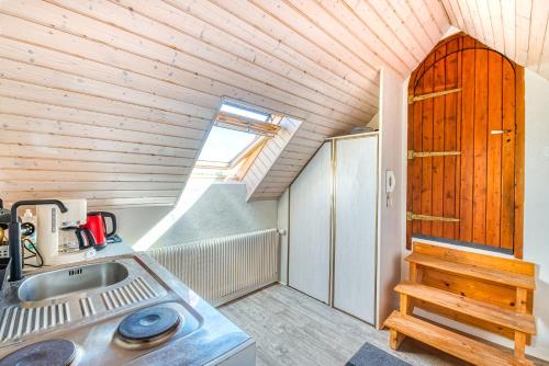 una piccola cucina con lavandino e soffitto in legno di Beau STUDIO vue LOIRE a Bouchemaine