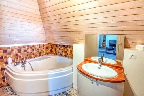 ein Badezimmer mit einer Badewanne und einem Waschbecken in der Unterkunft Beau STUDIO vue LOIRE in Bouchemaine