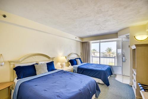 Duas camas num quarto com lençóis azuis e uma janela. em Daytona Beach Vacation Rental with Beach Access em Daytona Beach