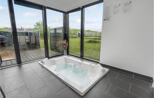 eine Badewanne in einem Zimmer mit großen Fenstern in der Unterkunft 3 Bedroom Lovely Home In Sydals in Skovby