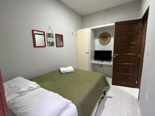 a small bedroom with a bed and a television at São José Village in Sobral