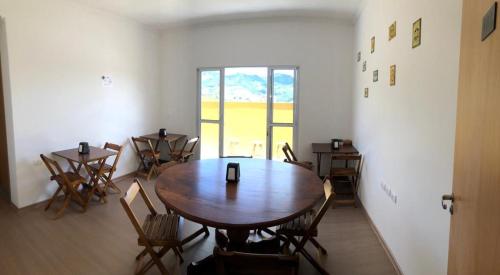 a room with a table and chairs and a window at Verissimu's Pousada in Paraisópolis