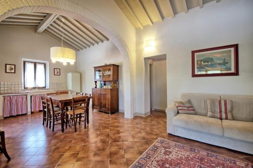 a living room with a couch and a table and chairs at Cuccardino by PosarelliVillas in Bibbona