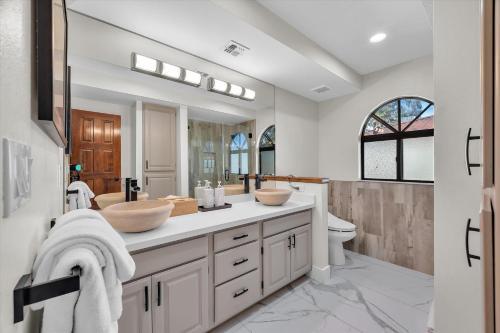 a bathroom with two sinks and a toilet at Ranch style villa with pool and spa in Las Vegas
